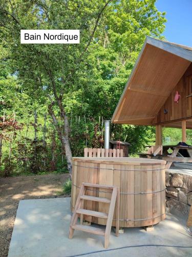 a wooden hot tub with a wooden bench next to it at Enjoy Eco Lodge in Onhaye