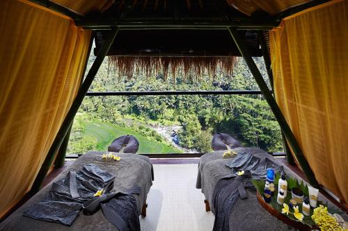 two beds in a room with a large window at Jungle Retreat by Kupu Kupu Barong in Ubud