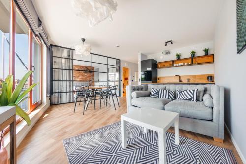 a living room with a couch and a table at Apartamenty Sun & Snow Waterlane Island z basenem in Gdańsk