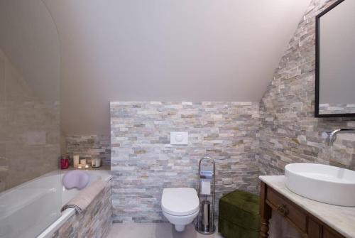 a bathroom with a tub and a toilet and a sink at Rosebury Cottage 1 bedroom Free parking 5min from Colmar in Wintzenheim