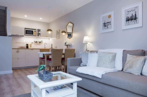 a living room and kitchen with a couch and a table at Rosebury Cottage 1 bedroom Free Street parking-5min from Colmar in Wintzenheim