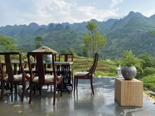 a table and chairs with a view of mountains at Tớ Dày Du Già Village in Làng Cac