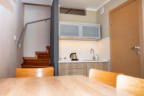 a kitchen with a table and chairs and a door at Leśna Oaza in Śliwice