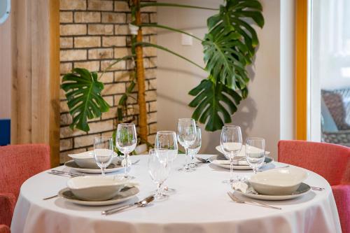 a table with a white table cloth and wine glasses at Leśna Oaza in Śliwice