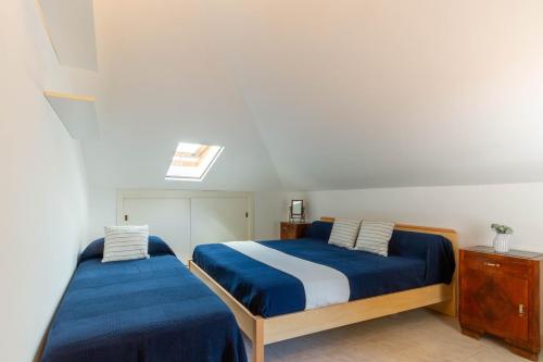 1 dormitorio con 2 camas con sábanas azules y blancas en Appartamento Mansarda Clori - MyHo Casa, en Alba Adriatica