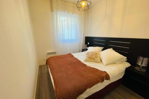 um quarto com uma cama com um cobertor castanho em Spacious and very central apartment with garden em Vannes