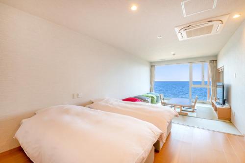 a bedroom with two beds and a view of the ocean at Umino Hotel Hajime in Beppu