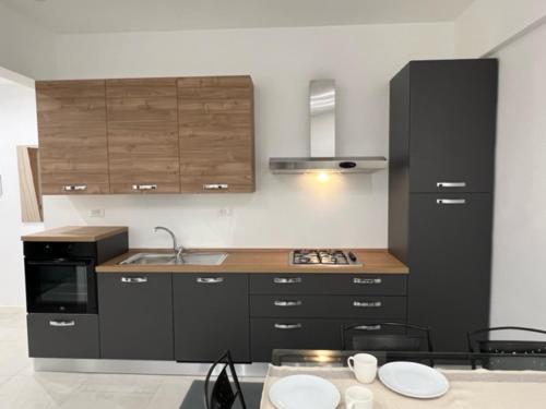 eine Küche mit schwarzen Schränken und einer Arbeitsplatte in der Unterkunft Appartamento La Fenice in Genua