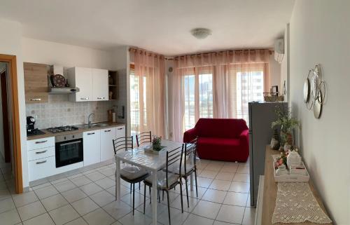 een keuken en een woonkamer met een tafel en een rode bank bij Casa Silvia in Pescara