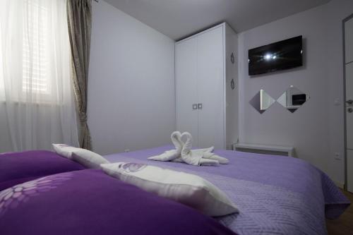 a bedroom with a purple bed with stuffed animals on it at Villa Nena in Makarska