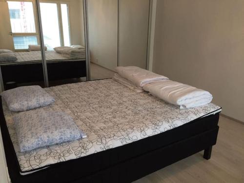 a bed in a room with a mirror at Uusi tilava kaksio Jyväskylän ydinkeskustassa 53 m2 in Jyväskylä