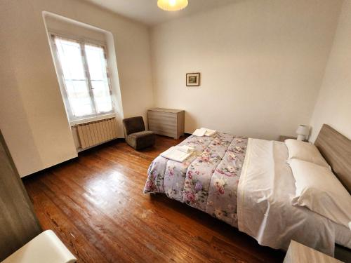 ein Schlafzimmer mit einem Bett, einem Fenster und einem Stuhl in der Unterkunft Raggio di sole in Levanto