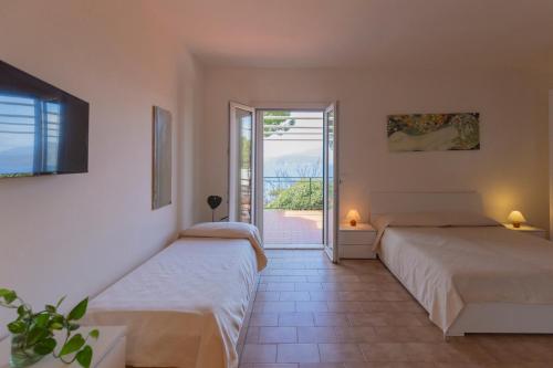 sypialnia z 2 łóżkami i drzwiami na patio w obiekcie HelloElba Residenza Peducelli w mieście Capoliveri