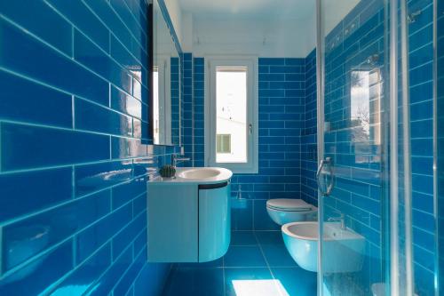 niebieska łazienka z 2 toaletami i umywalką w obiekcie HelloElba Residenza Peducelli w mieście Capoliveri