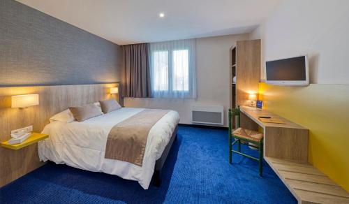 a hotel room with a bed and a television at Logis Hôtel Le Pan De Bois in Bréviandes