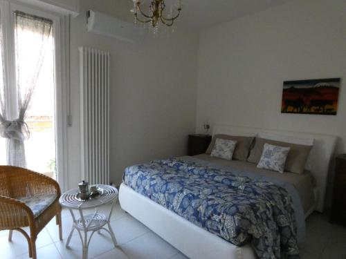1 dormitorio con 1 cama, 1 silla y 1 ventana en Casa LorEn, en Pesaro