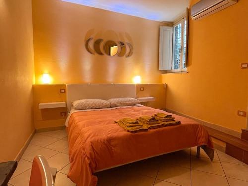 a bedroom with a bed with orange sheets and a window at Piazza Napoleone Sweet apartment in Lucca