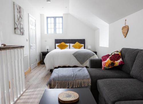 uma sala de estar com uma cama e um sofá em Shannon Castle Holiday Cottages Type A 