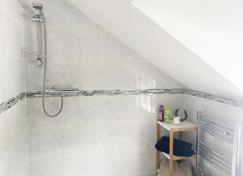 a bathroom with a shower and a stool in it at Shannon Castle Holiday Cottages Type A 