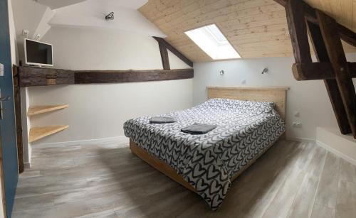 1 dormitorio con 1 cama en una habitación con suelo de madera en Chambre avec SDB privative, cuisine et salon partagés, 