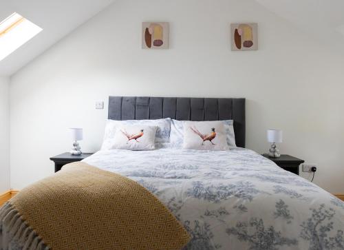 1 dormitorio con 1 cama con 2 pájaros en las almohadas en Shannon Castle Holiday Cottages Type B 