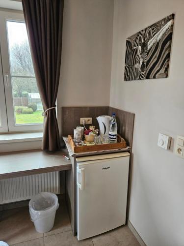 a kitchen with a small refrigerator and a window at B&B OLEN in Olen