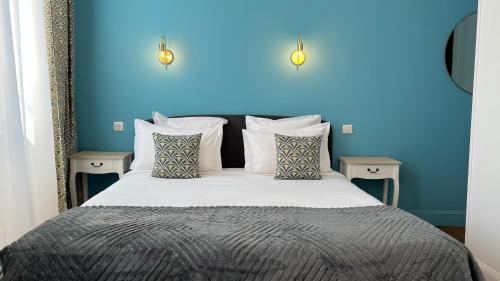 a bedroom with a bed with a blue wall at Jardin Bleu - Chambres d'hôtes in Saint-Girons