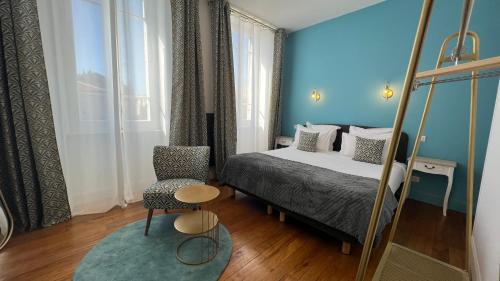 - une chambre avec un lit, une chaise et un miroir dans l'établissement Jardin Bleu - Chambres d'hôtes, à Saint-Girons