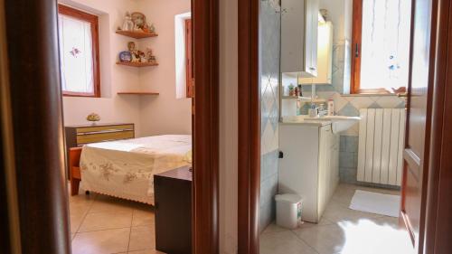 Habitación pequeña con cama y lavamanos en Casa Pia, en Oliena