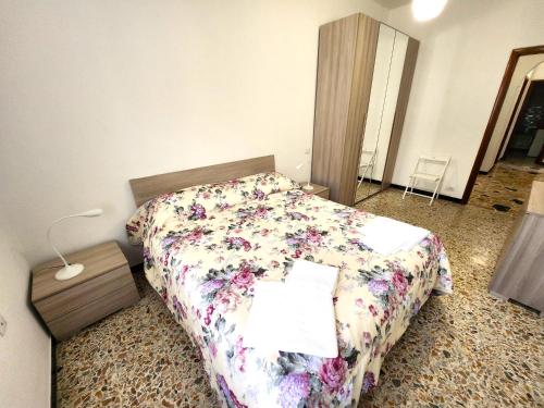 a bedroom with a bed with a floral comforter at Gambero rosso in Levanto