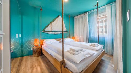 1 dormitorio con cama colgante en una habitación azul en Apartamenty Sun & Snow Aura 40 en Gdansk