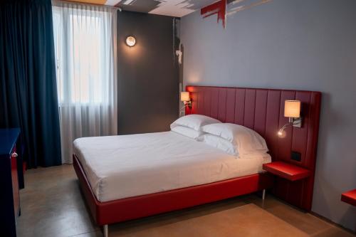a bedroom with a large bed with a red headboard at K MODERN HOTEL in Peschiera del Garda