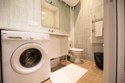 - un lave-linge dans la salle de bains pourvue de toilettes dans l'établissement Cosy studio on bastille, à Paris