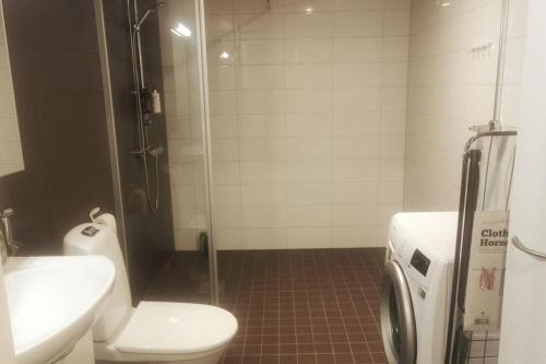 a bathroom with a toilet and a sink and a shower at Alvar, Tilava uusi kaksio ydinkeskustassa 53 m2 in Jyväskylä