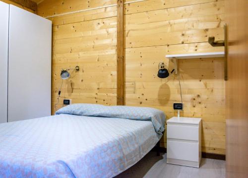 a bedroom with a bed and a wooden wall at Elbadoc Camping Village in Cavo