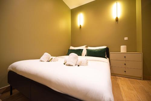 - une chambre avec un grand lit blanc aux murs verts dans l'établissement Cosy studio on bastille, à Paris