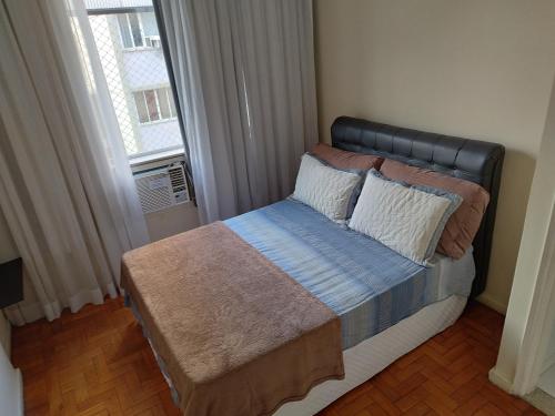 um pequeno quarto com uma cama e uma janela em Boemia Carioca Lapa no Rio de Janeiro