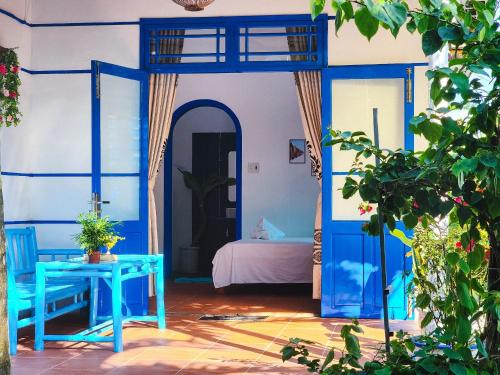 a room with a blue room with a bed and a table at Dragon Sea Homestay in Hoi An