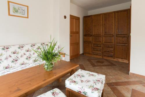 a room with a bench and a table with a vase of flowers at Hezká chalupa in Strmilov