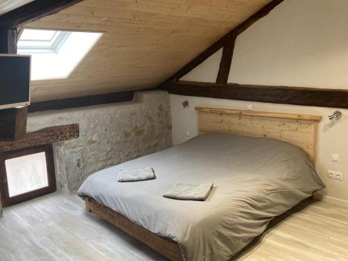 a bedroom with a large bed in a attic at chambre avec SDB privative, salon et cuisine partagés 