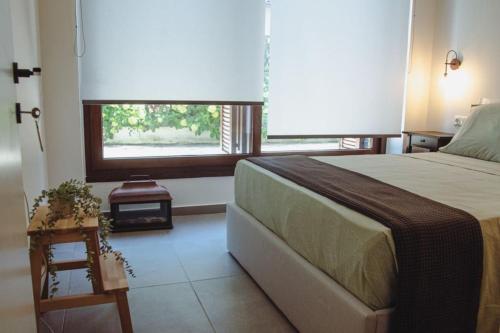 a bedroom with a large bed and a window at Sirokos House in Agios Ioannis Pelio