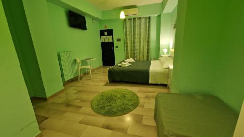 a green room with a bed and a table at Bari Vecchia Dimora in Bari