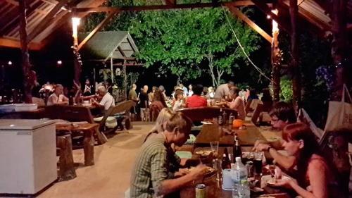 a group of people sitting at tables in a restaurant at KohChangResortRanong in Koh Chang Ranong