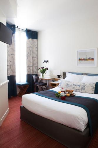a hotel room with a large bed and a table at Hotel La Manufacture in Paris