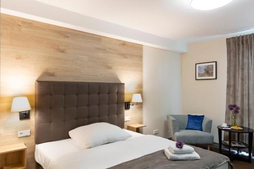 a hotel room with a bed and a chair at Dominik Hotel & Eventsaal in Paderborn