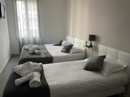 Dos camas en una habitación de hotel con toallas. en Hôtel Anna Livia en Cannes