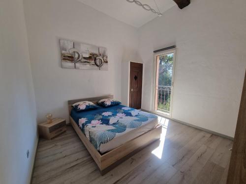 een slaapkamer met een bed in een kamer met een raam bij Appartement dans ancien moulin à huile rénové in Grasse