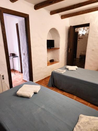 a room with two beds in a room at Posada La Plaza in Canillas de Albaida