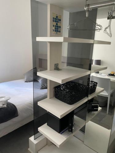ein Schlafzimmer mit weißen Regalen neben einem Bett in der Unterkunft Hôtel Anna Livia in Cannes