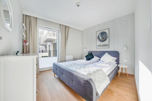 a bedroom with a blue bed and a window at Apartamenty Sun & Snow Angielska Grobla in Gdańsk